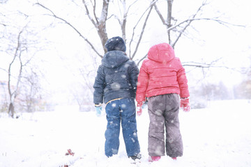 Fototapeta na wymiar Kids walk in the park first snow