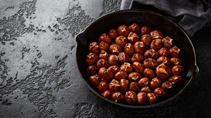 Roasted chestnuts served in cast iron vintage pan.