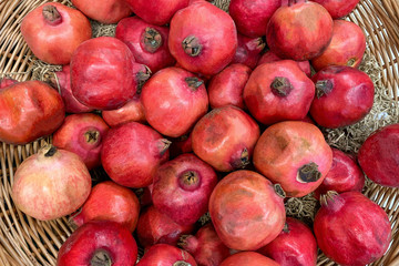 Fresh pomagranates in a basket (top view)