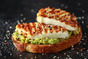 Avocado and grilled haloumi cheese toast with nigella and sesame seeds. healthy breakfast