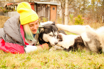 Girl in a sign cap in two Husky. Sleeping bag Mountains Travel from Husky. Two dog