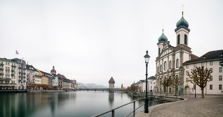 Naklejka premium Lucerne, LU / Switzerland - November 9, 2018: the famous Swiss city of Lucerne cityscape skyline and Kappel bridge with water tower panorama view long exposure