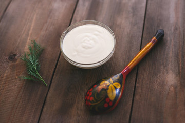 Mayonnaise in a plate on a natural wooden table. Russian kitchen