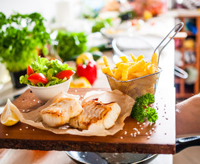 Fish dish - fried fish fillet with french fries and vegetables