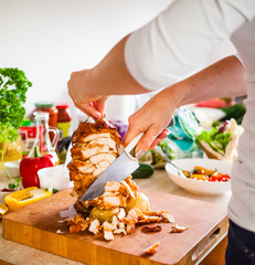 Woman cutting chicken meat