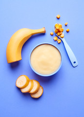 Bowl of baby porridge on blue, from above