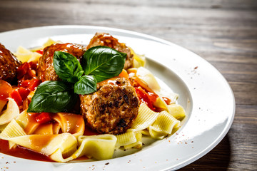 Pasta with meatballs on wooden background