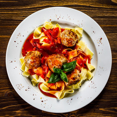 Pasta with meatballs on wooden background