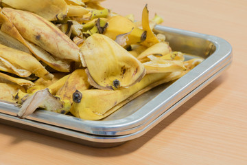banana peel in tray on wood table background
