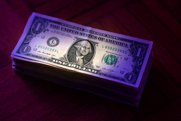 close up American one dollar bills pile on wooden table