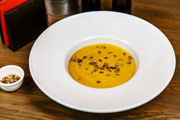 Pumpkin cream soup poured into a large white plate