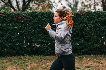 Woman running. Female runner jogging, training for marathon. Fit girl fitness athlete model exercising outdoor.