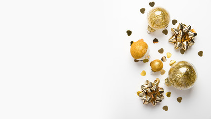 Fototapeta premium Merry Christmas and Happy Holidays greeting card. New Year. Golden ornaments on white background top view. Winter holidays.