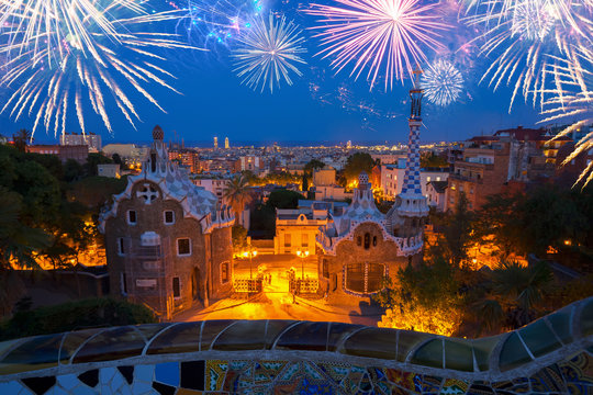 Gaudi bench and cityscape of Barcelona from park Guell at night with fireworks, Spain
