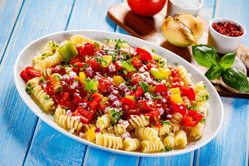 Pasta with vegetables on wooden background
