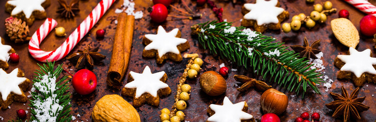 Christmas Background with Star Gingerbread Cookies and Holiday Decorations on Old Rusty Background. Selective focus.
