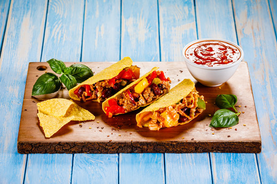 Tacos on cutting board on wooden table
