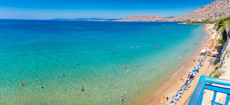 Pefkos beach with holiday-makers having fun in village of Pefkos - PANORAMA (Rhodes, Greece)