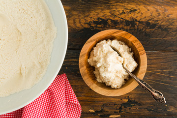 Cooking of muffins, ricotta mixed with sugar and flour. Wooden table, top view