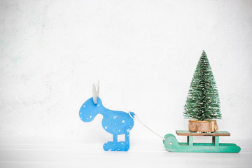 Christmas tree on a sleigh driven by a deer. New year concept. Festive attributes. White background. Place for text.