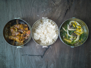 Selective focus the delicious meal consists of Chicken Oyster Sauce, White Rice and Vegetable Soup on the top of wooden table.
