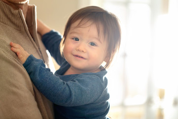 Fototapeta premium Happy toddler boy being held and cared for by his parents