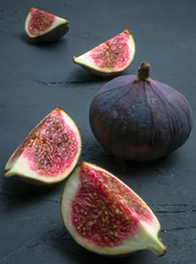 Fresh figs. Food photography. Creative scheme of whole and sliced figs on a dark background, inscribed in a rectangle. Copy space