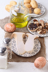 Fototapeta na wymiar mushrooms eggs potatoes and other raw ingredients on textured white base