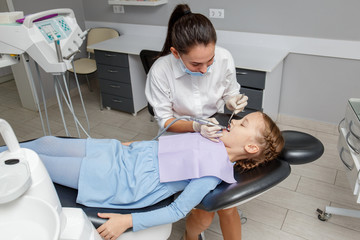 Child girl having professional dental cleaning in dentist office