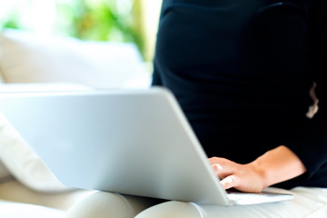 Fototapeta premium Young woman with a laptop computer in a bright interior room