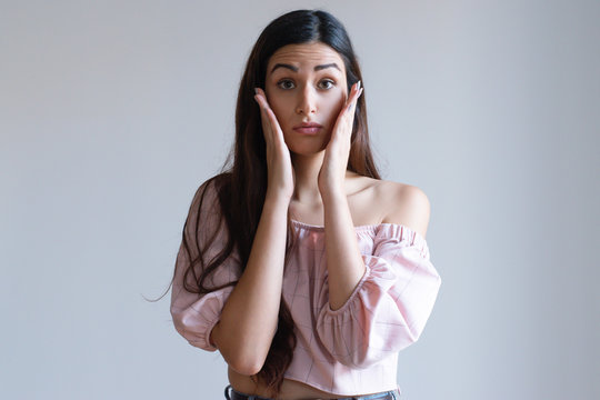 Nervous Pretty Caucasian Girl Holding Hands Near Face. Young Female Student In Light Pink Top Looking In The Mirror And Checking Make Up. First Date Concept