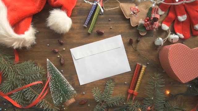 Writing a letter to Santa Claus for Christmas, blank envelope on table among festive holiday decoration