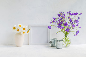 Mockup with a white frame and summer flowers in a vase