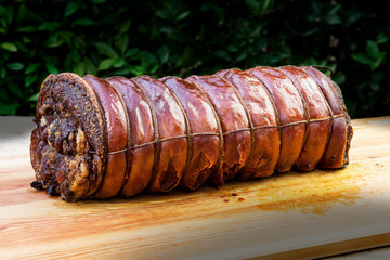 Whole Cooked roasted rolled pork on chopping board
