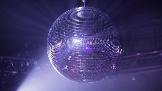 Mirror disco ball at the party. Rotates, reflecting the rays of light from the spotlights.