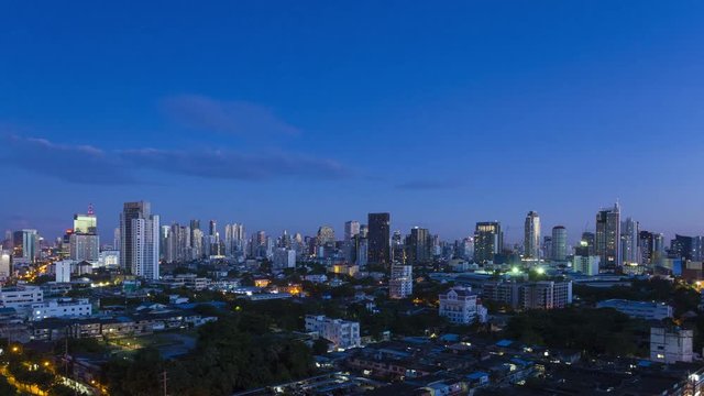 Zoom out Bangkok skyline time-lapse morning transition from dark to sunrise then blue sky day of downtown and city panoramic skyline along Sukhumvit Road. 16:9 4k at 30fps