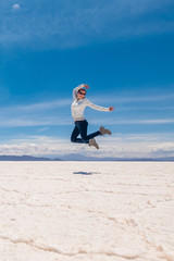 Fototapeta na wymiar Girl in a jump in sunshine Salar de Uyuni