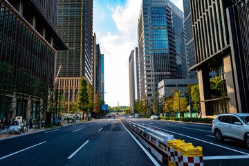 Obraz premium 水平線に向かって道路が走りその脇にはいくつものオフィスビルが立ち並ぶ