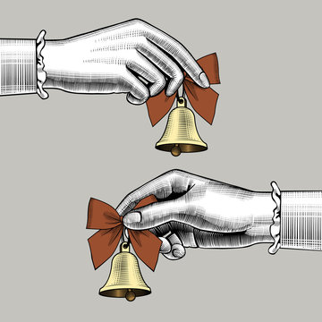 Female hands holding retro bells with red bows