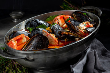 Seafood soup with mussels and crabs in metal pot