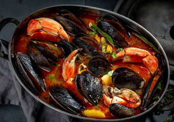 Seafood soup with mussels and crabs in metal pot