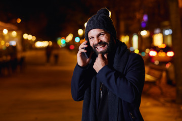 Hombre joven con barba en una calle, en una noche de invierno