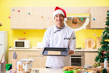 Young chef husband working in kitchen at Christmas eve 