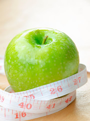 Green apple core and measuring tape. Diet concept