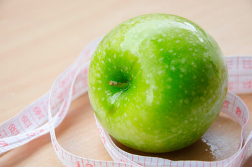 Green apple core and measuring tape. Diet concept