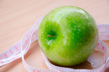 Green apple core and measuring tape. Diet concept