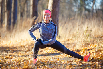 Young woman stretching before jogging in park