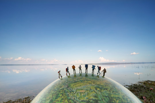 miniature figure people backpack miniature figure people backpack standing on globe with blue sky background