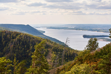 Obraz premium River against a cloudy sky with clouds and forest.