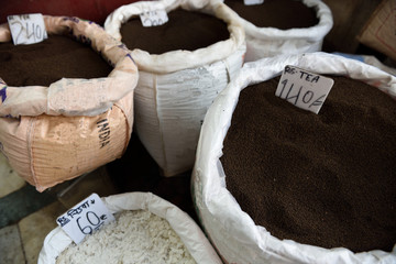 Several large baskets of fresh raw dark Indian tea in the spice market of Old Delhi, India. 